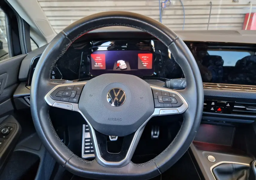 Volant en cuir noir avec commandes intégrées dans l'habitacle moderne d'une Volkswagen Golf VIII 2.0 TDI 115CH United 2021.