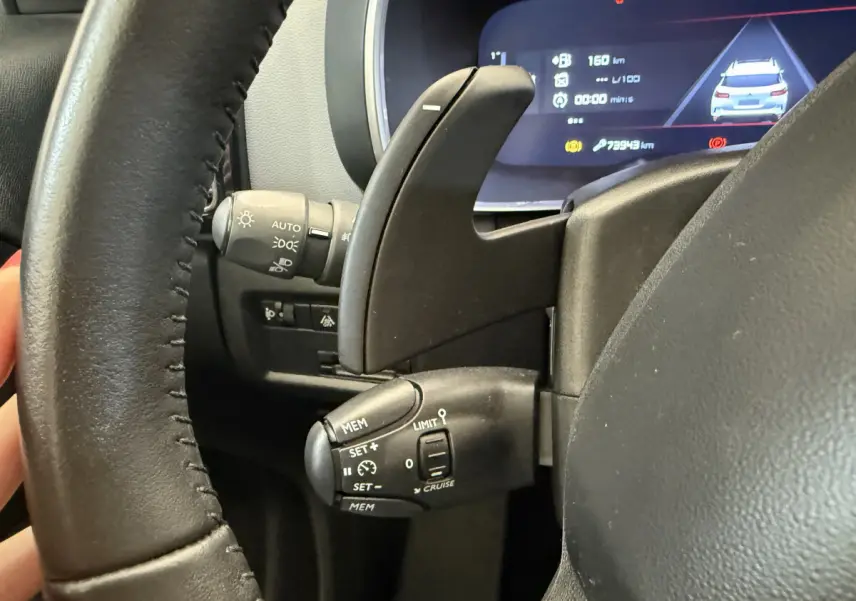 Gros plan sur le volant cuir noir de la Citroën C5 Aircross 2020, avec commandes de régulateur et affichage numérique.