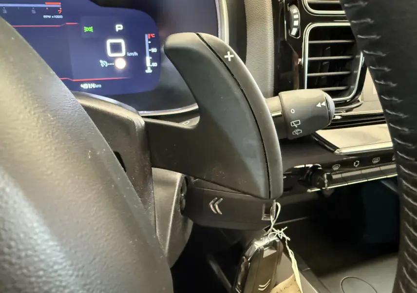 Gros plan sur la commande de palette de vitesse + du volant cuir et tableau de bord numérique du Citroën C5 Aircross gris clair 2020.