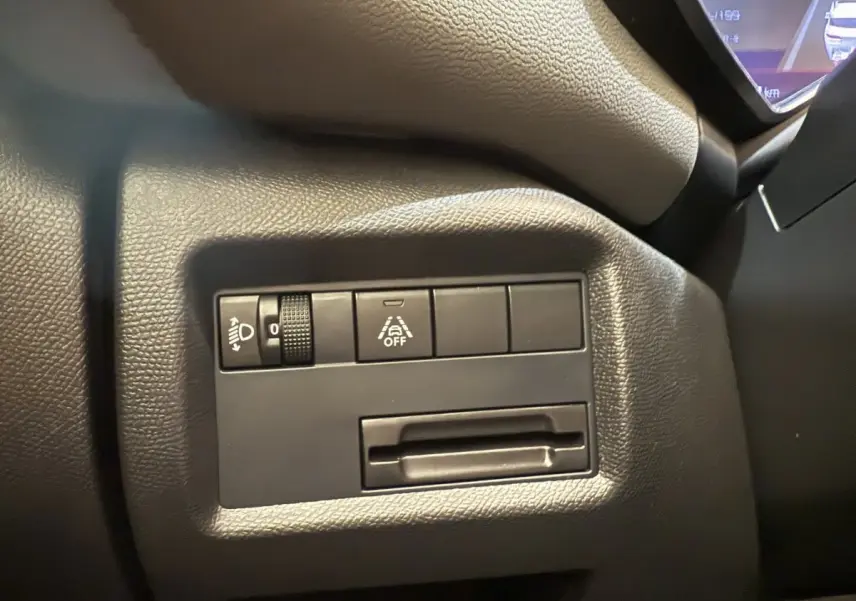 Gros plan sur les commandes d'éclairage et d'aide à la conduite côté gauche du tableau de bord du Citroën C5 Aircross gris clair.
