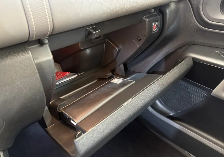 Gros plan de la boîte à gants ouverte côté passager du Citroën C5 Aircross Business avec intérieur noir et rangement visible.