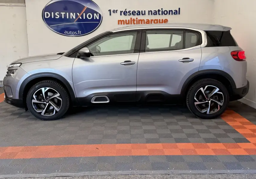 Profil droit d'un Citroën C5 Aircross gris clair 2020 avec jantes alliage et toit noir contrasté.
