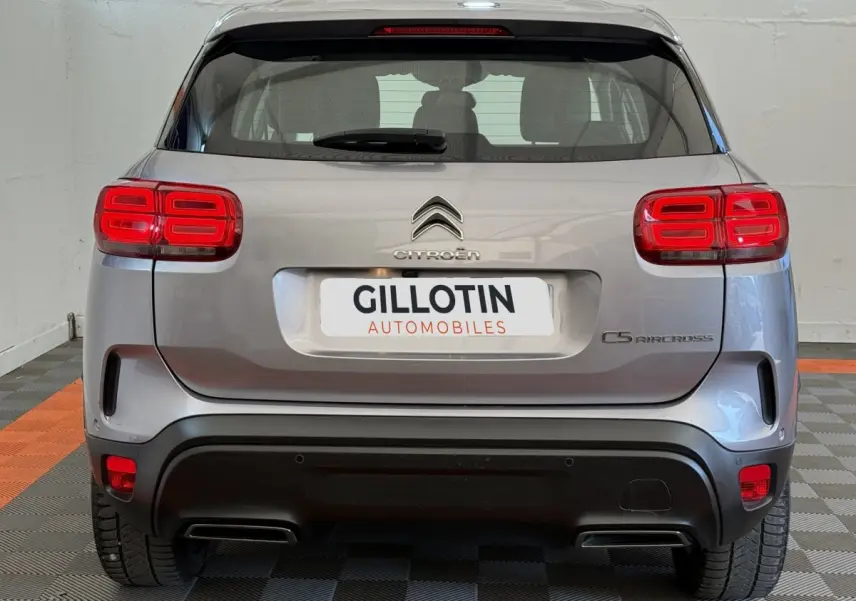 Vue arrière d'un Citroën C5 Aircross gris clair avec feux arrière LED et double sortie d'échappement intégrée.