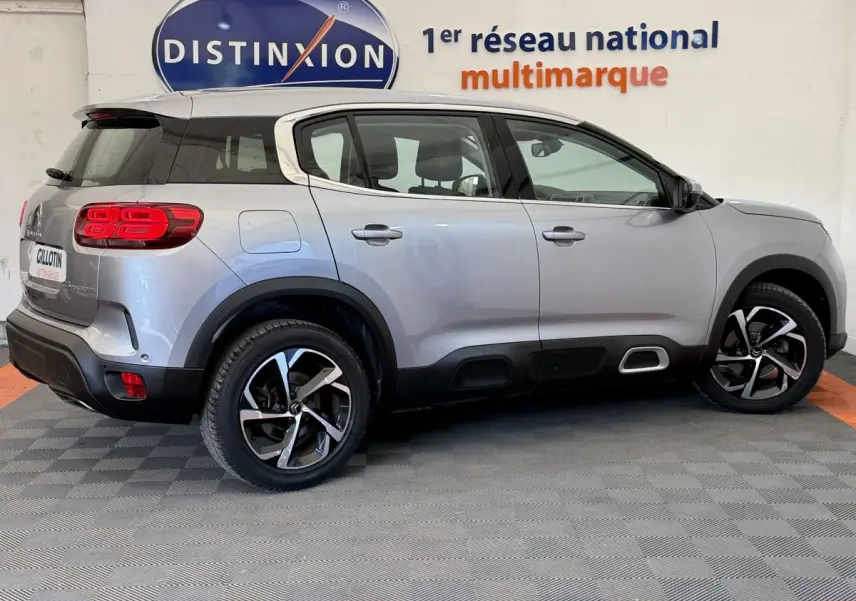 Profil droit d'un Citroën C5 Aircross gris clair 2020 avec jantes noires et détails noirs sur les bas de caisse.
