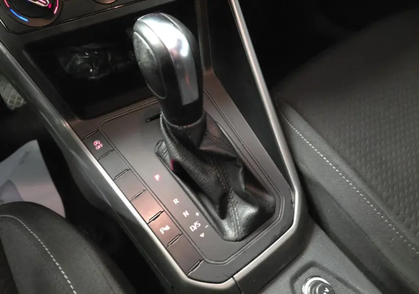 Le levier de vitesses automatique en cuir noir de la Volkswagen Polo 1.6 TDI Lounge Business 2020, vue rapprochée de la console centrale.