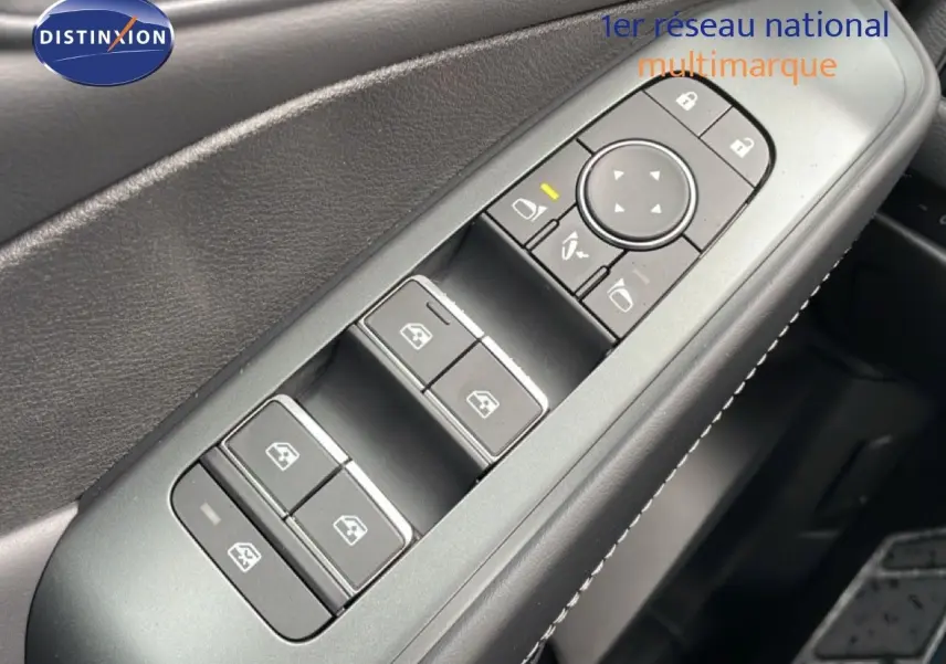 Gros plan sur la commande des vitres électriques côté gauche intérieur du Nissan Qashqai gris Squale Métal 2026.