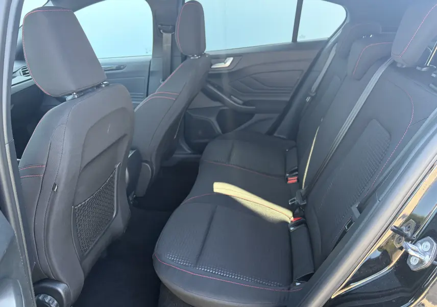 Vue latérale droite de la banquette arrière noire avec surpiqûres rouges dans une Ford Focus IV ST-Line X 2025.