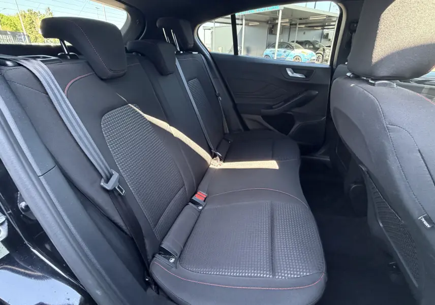 Vue intérieure côté droit de la banquette arrière noire avec surpiqûres rouges de la Ford Focus IV ST-Line X 2025.