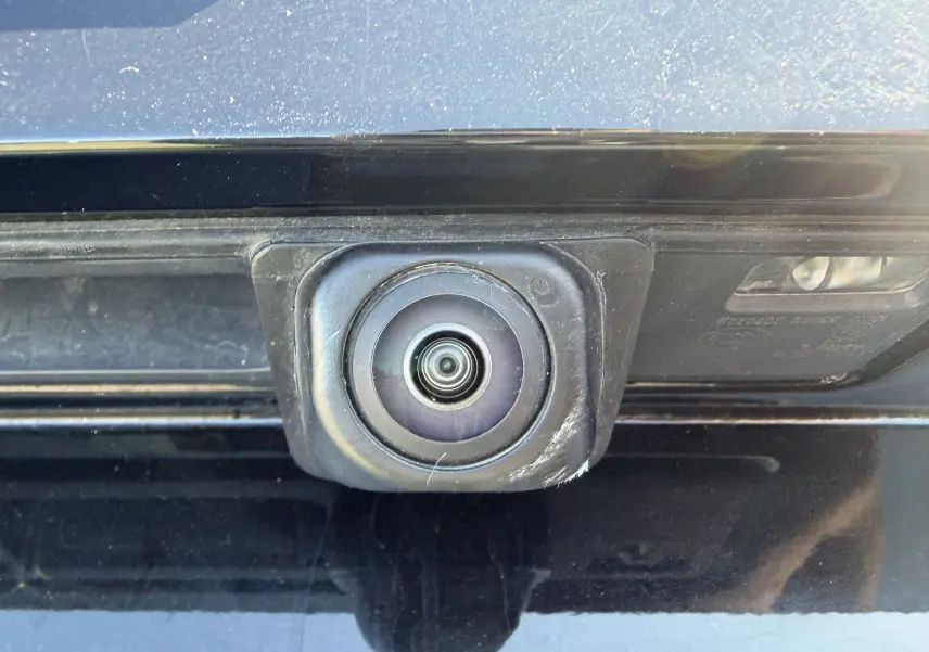 Gros plan sur la caméra de recul noire intégrée à la malle arrière d'une Ford Focus ST-Line X noir agate.