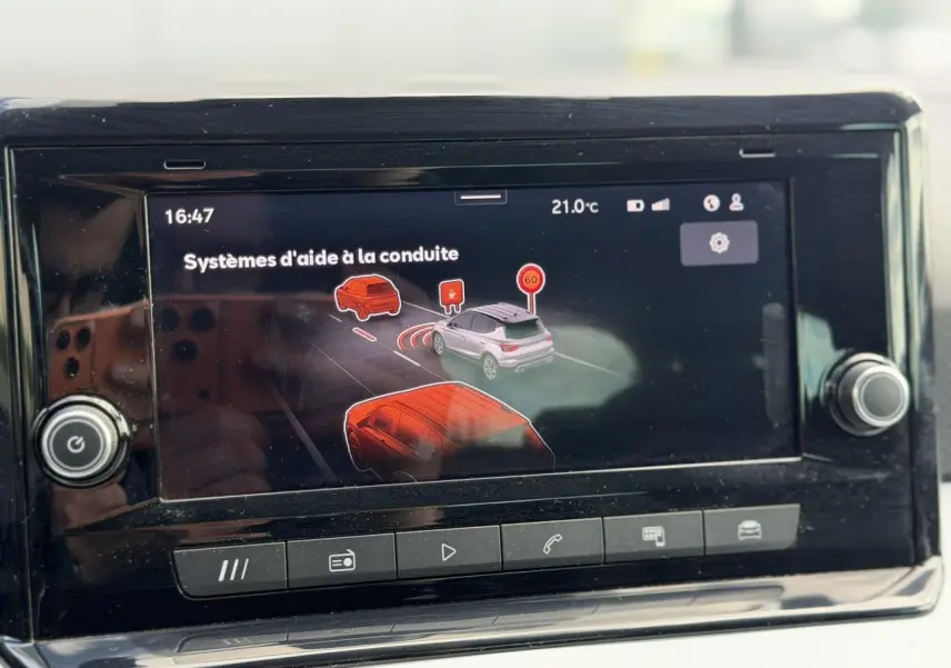 Écran tactile du système d'info-divertissement montrant les aides à la conduite dans un SEAT Arona Rouge Désir.