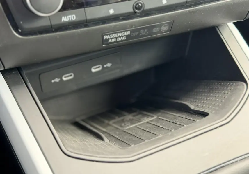 Gros plan sur la console centrale du SEAT Arona TSI 115 Style 2025, montrant les ports USB et le rangement noir mat.