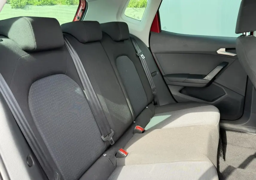 Vue intérieure de la banquette arrière noire du SEAT Arona 2025, côté droit avec ceintures de sécurité visibles.
