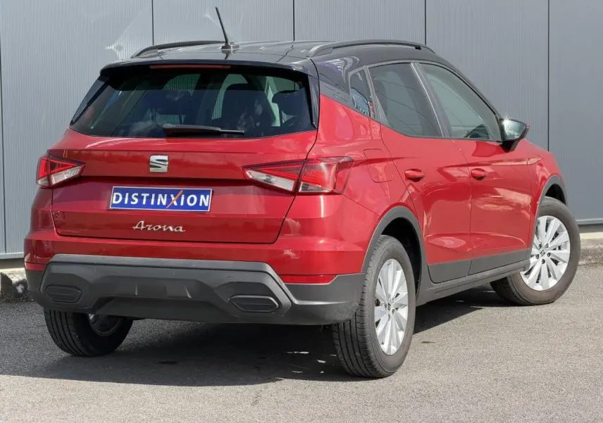 Vue 3/4 arrière droite d'un SEAT Arona Rouge Désir avec toit noir et jantes alliage 16 pouces.