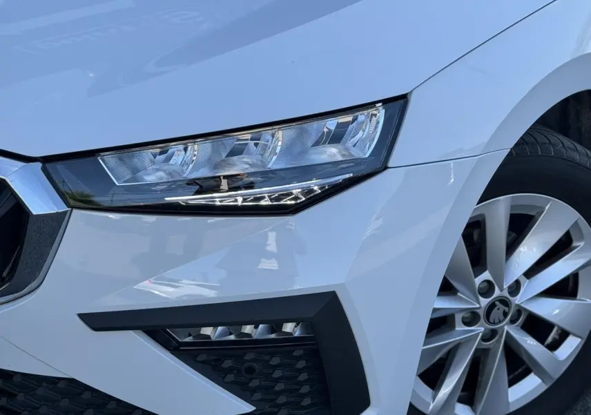 Gros plan sur l'avant droit blanc glacier d'une Skoda Scala TSI 116, mettant en valeur le phare LED et la jante alliage.