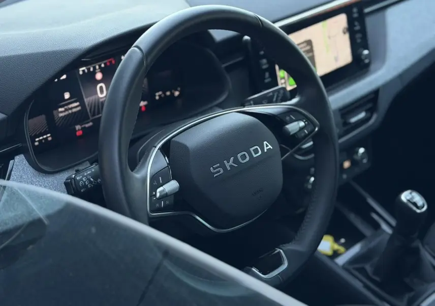 Vue rapprochée de l’intérieur d’une Skoda Scala 2025, volant cuir multifonctions et écran tactile central visible.