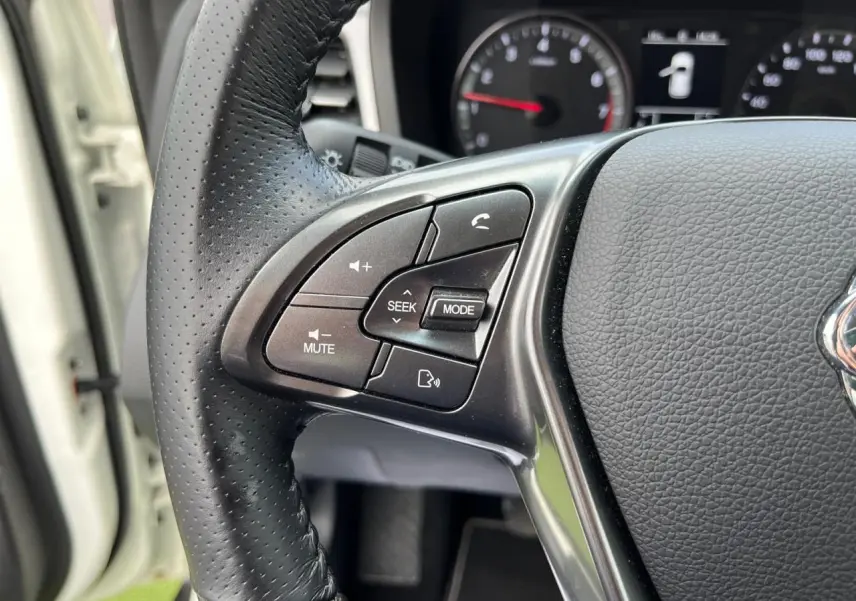 Gros plan sur les commandes audio et téléphone au volant cuir perforé du SSANGYONG TIVOLI blanc 2021.