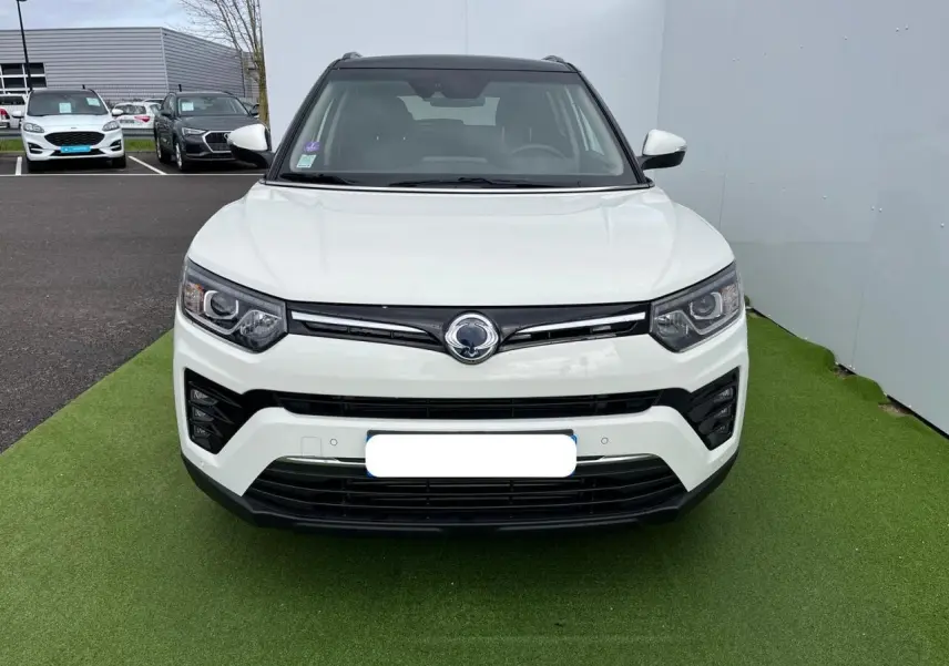 Vue frontale d'un SsangYong Tivoli blanc 2021 avec calandre noire et phares LED distinctifs.