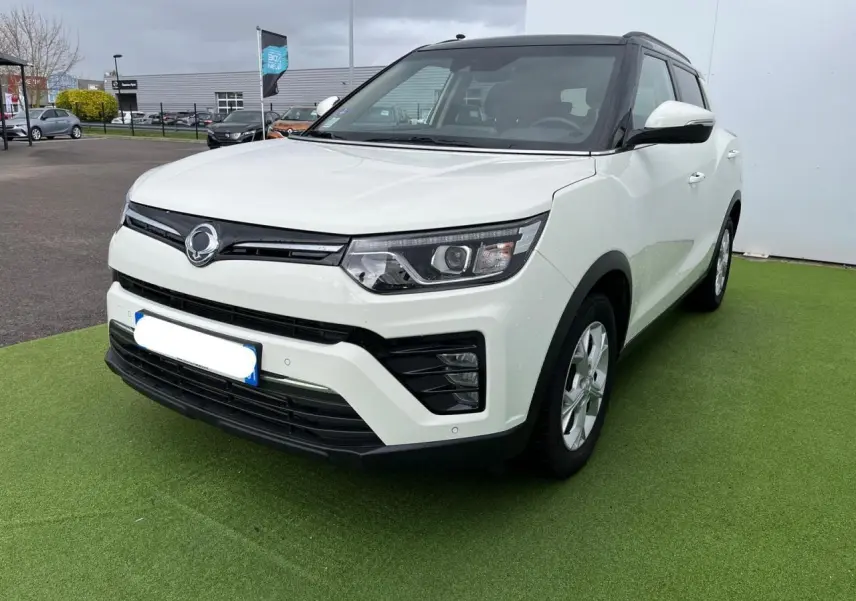 Vue 3/4 avant d’un SsangYong Tivoli blanc avec toit noir, jantes alliage 16 pouces et rétroviseurs blancs.