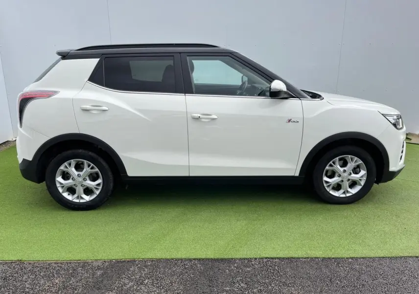 Vue de profil côté gauche d'un SsangYong Tivoli blanc avec toit noir et jantes alliage 16 pouces.