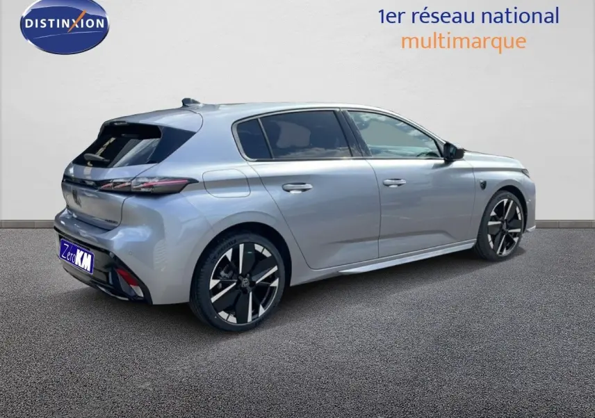 Vue 3/4 arrière droite d'une Peugeot 308 gris Artense métal avec jantes noires et détails modernes.