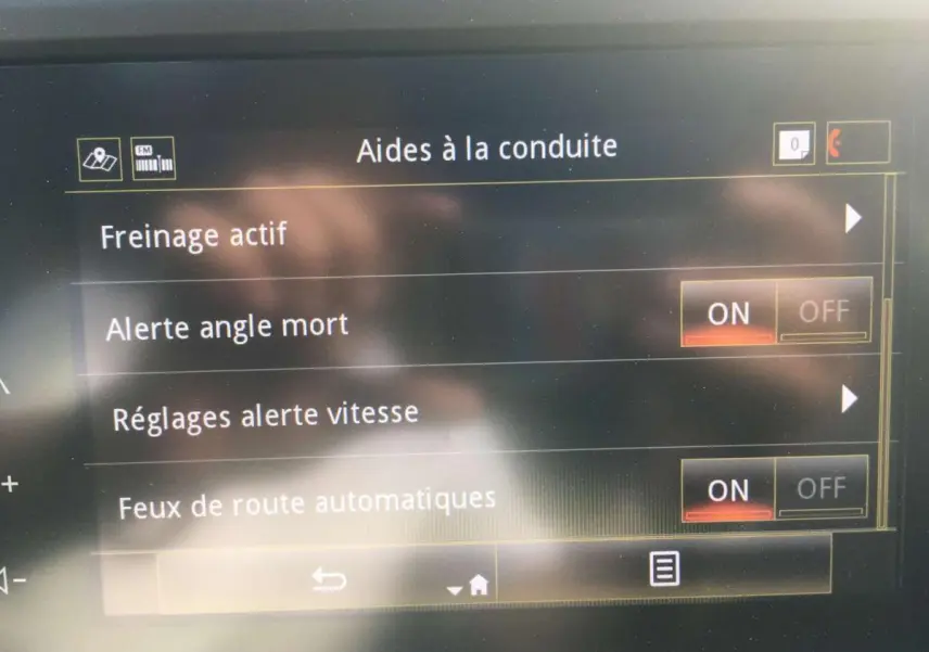 Écran tactile intérieur montrant les aides à la conduite activées sur Renault Kadjar gris titanium, vue frontale rapprochée.