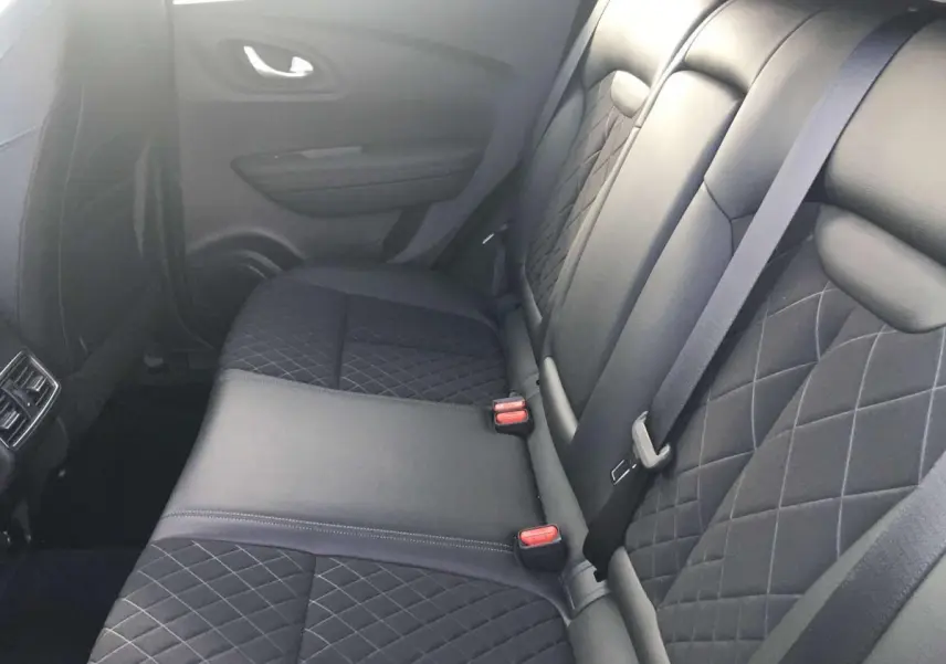 Vue latérale intérieure montrant la banquette arrière en cuir noir matelassé du Renault Kadjar gris titanium.