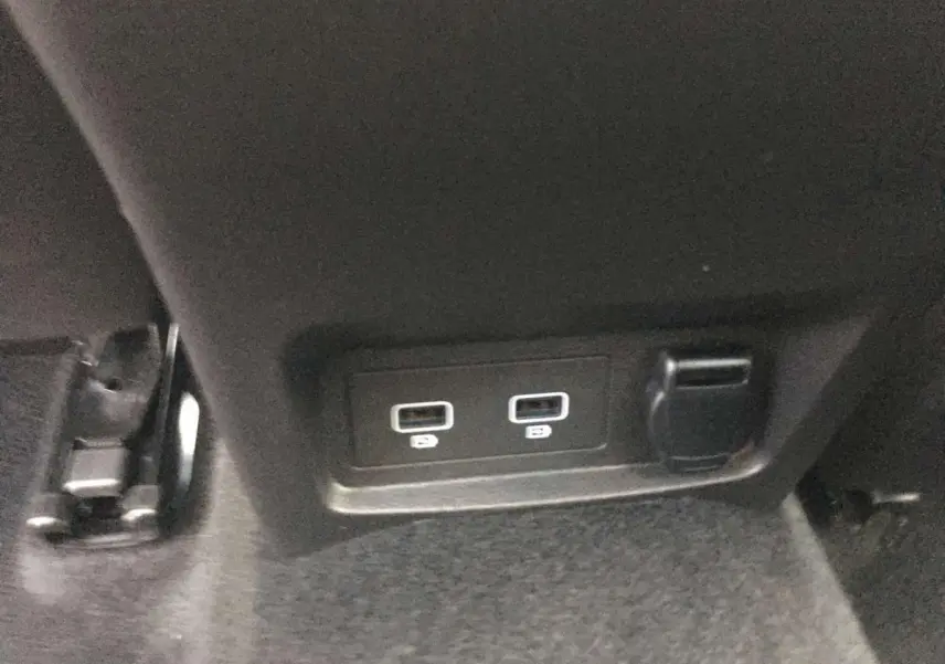 Prise USB double et prise 12V sur la console arrière d’un Renault Kadjar gris titanium, vue rapprochée.