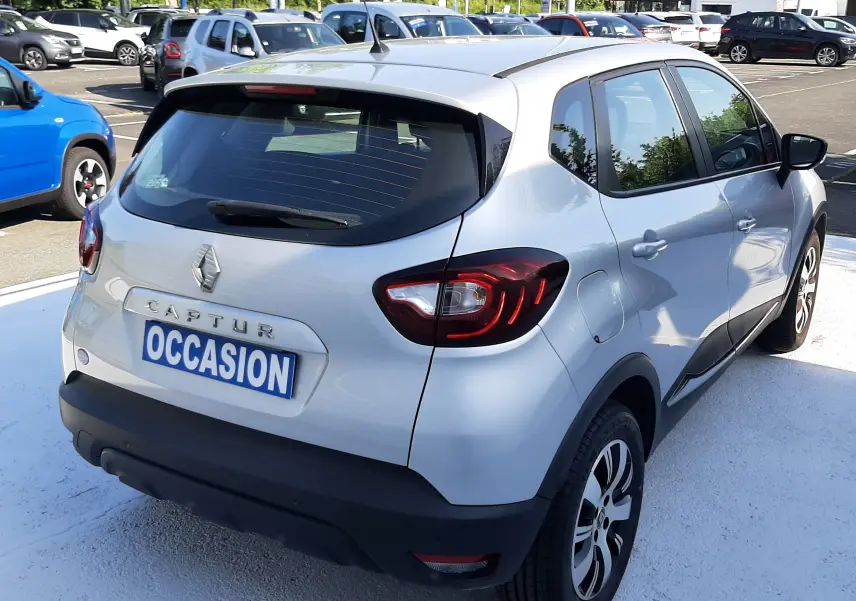Renault Captur gris platine métal vu de profil côté gauche, avec jantes alliage et feux arrière LED distinctifs.