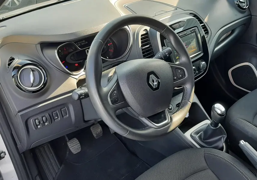 Intérieur du Renault Captur 2019, vue côté conducteur sur le volant multifonction et la console centrale noire.