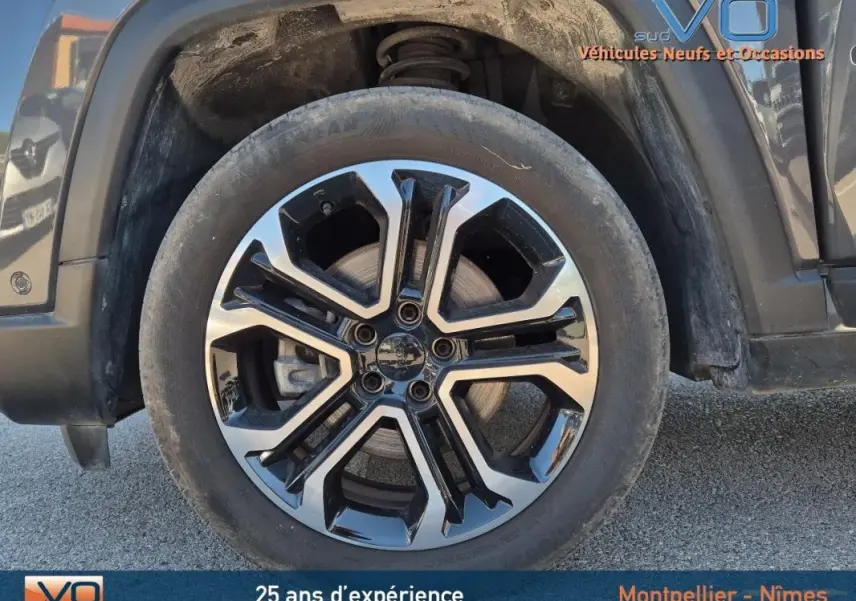 Gros plan sur la jante alliage 18 pouces noire et argentée du Jeep Compass gris 2024, côté gauche avant.