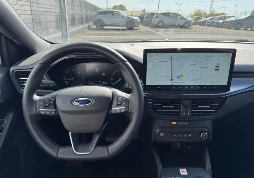 Vue intérieure avant de la Ford Focus IV ST-Line X, tableau de bord noir avec écran tactile large et volant multifonction.