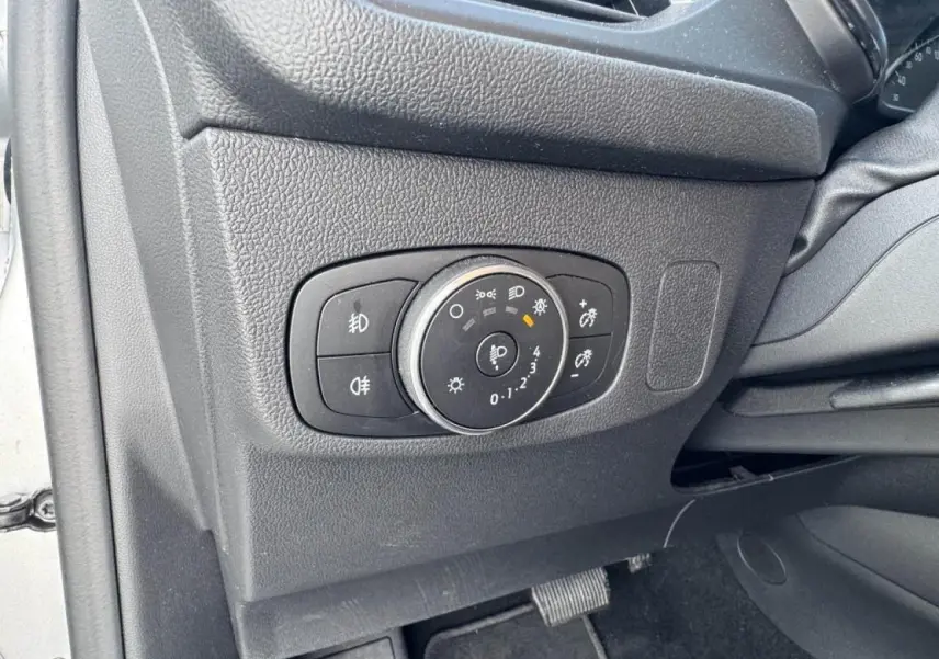 Gros plan sur le panneau de commande des phares côté gauche intérieur d'une Ford Focus IV gris Moondust Metal.