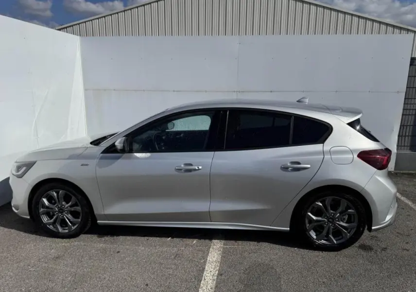 Vue de profil côté gauche de la Ford Focus IV ST-Line X gris Moondust métallisé avec jantes alliage 17 pouces.