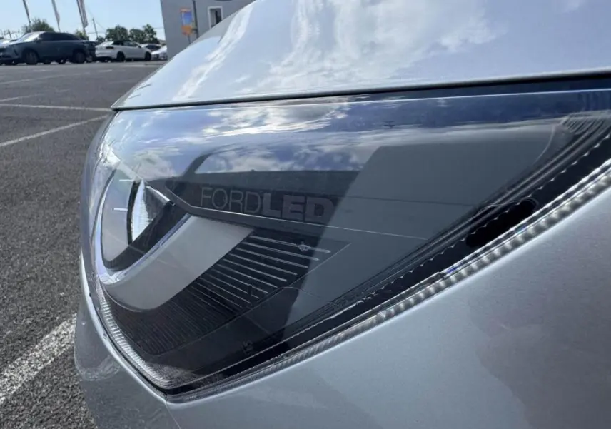 Gros plan sur le phare avant gauche gris Moondust Metal de la Ford Focus IV ST-Line X avec éclairage LED distinctif.