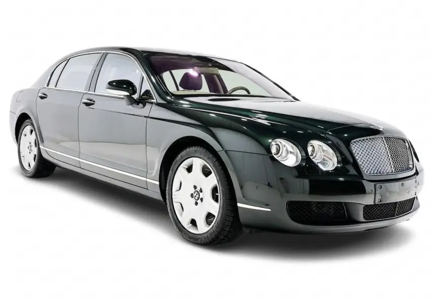 Bentley Continental Flying Spur vert foncé vue 3/4 avant droit avec calandre chromée et jantes blanches.