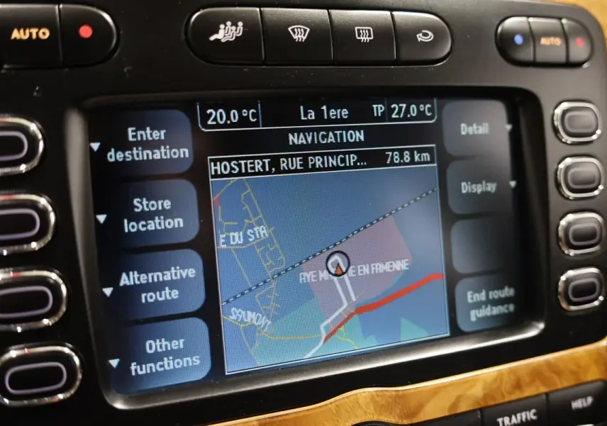 Gros plan sur l’écran de navigation intégré au tableau de bord en bois clair d’une Bentley Continental Flying Spur.
