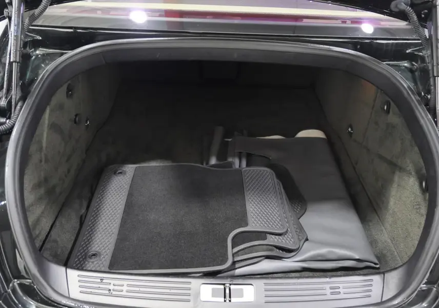 Vue du coffre ouvert d'une Bentley Continental Flying Spur 2006 vert foncé, montrant tapis et revêtement intérieur gris.