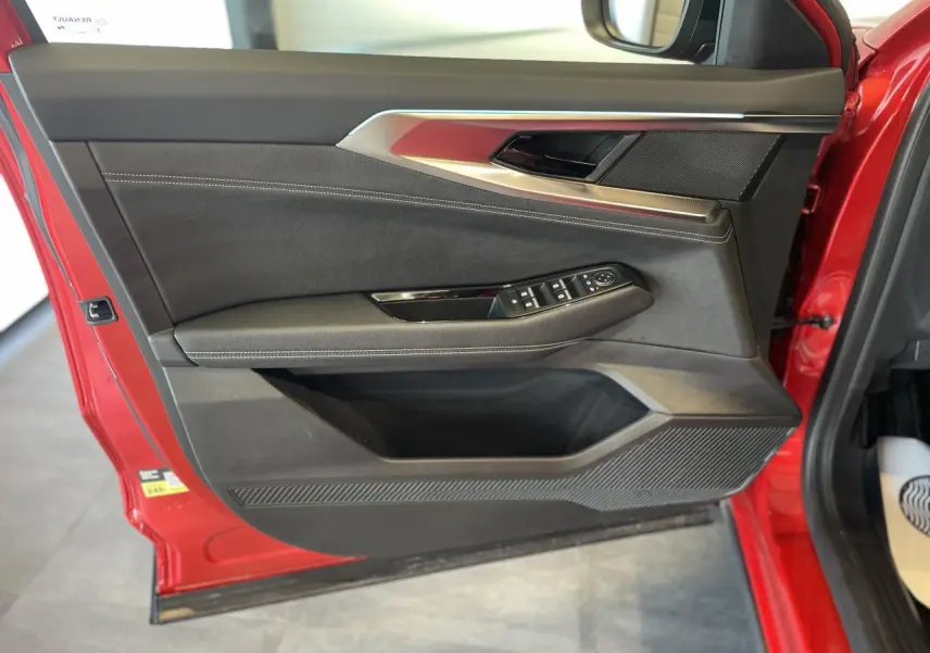 Vue intérieure de la porte avant gauche rouge de la Renault Rafale 2025 avec garniture textile refined et commandes électriques.