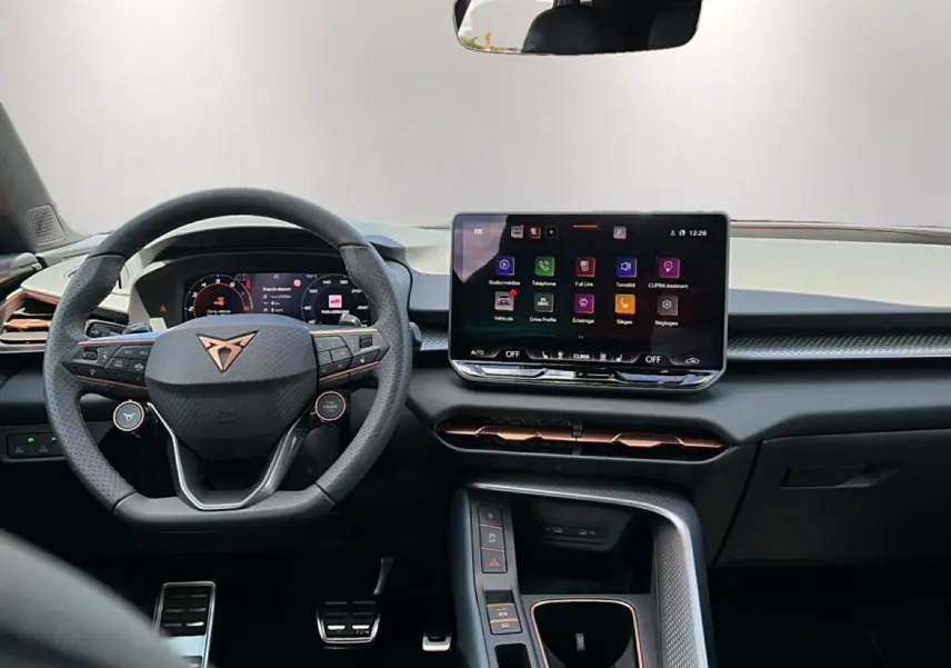 Vue intérieure du poste de conduite de la CUPRA TERRAMAR 1.5 etsi hybrid avec volant cuir multifonction et écran tactile central.