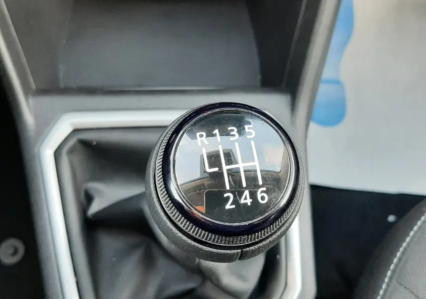 Gros plan sur le levier de vitesses manuel noir du Dacia Jogger 1.0 ECO-G 100CH, entouré d'un cadre gris.