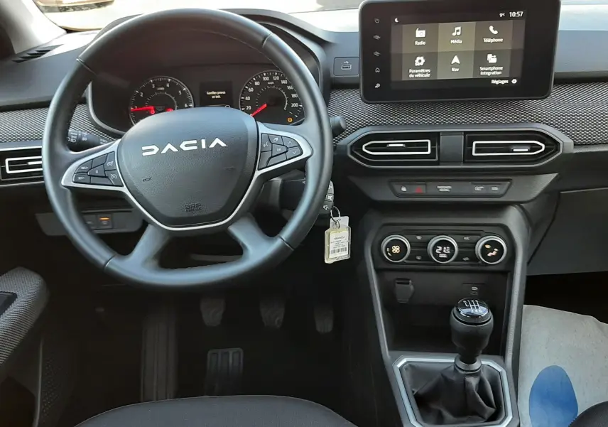 Vue intérieure du tableau de bord et volant du Dacia Jogger 2025, avec écran tactile central et boîte manuelle.