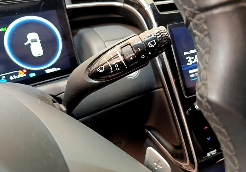 Gros plan sur la commande d’essuie-glace à gauche du volant cuir du Hyundai Tucson 1.6 Hybrid 230 gris foncé 2022.