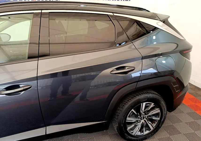 Vue latérale droite du Hyundai Tucson 1.6 Hybrid 230 Creative gris foncé, mettant en valeur les lignes et la roue arrière.
