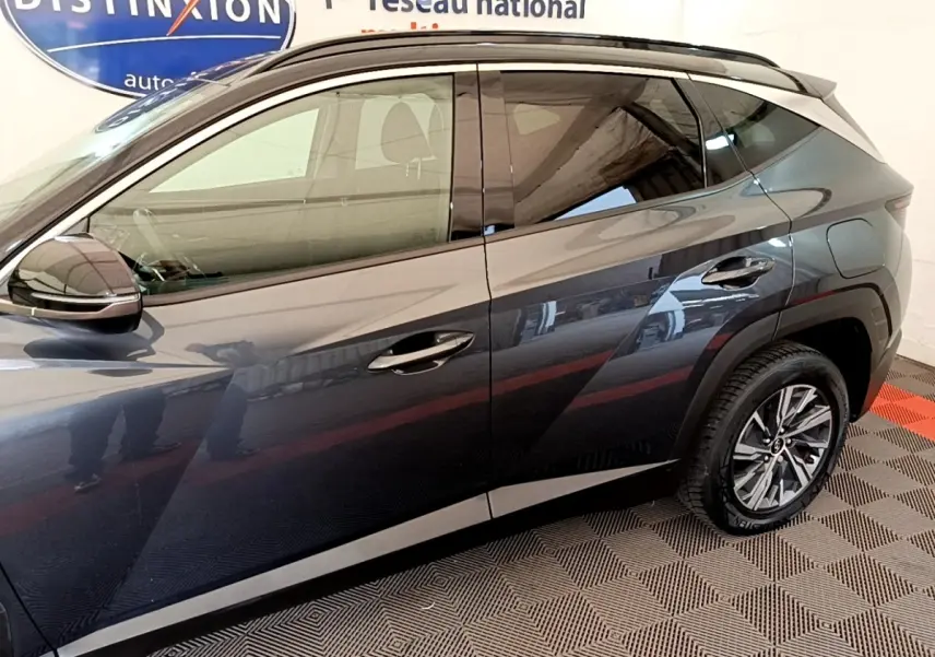 Vue latérale droite d'un Hyundai Tucson gris foncé 2022 avec jantes alliage et poignées chromées.