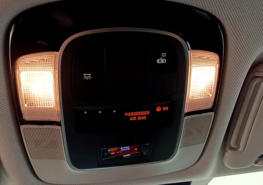 Vue intérieure en gros plan du plafonnier avec éclairage et indicateur airbag passager allumé dans un Hyundai Tucson gris foncé.