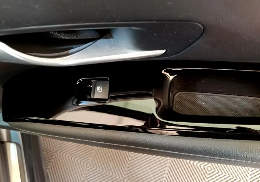 Gros plan sur la commande de lève-vitre côté conducteur du Hyundai Tucson gris foncé 2022, finition Creative.