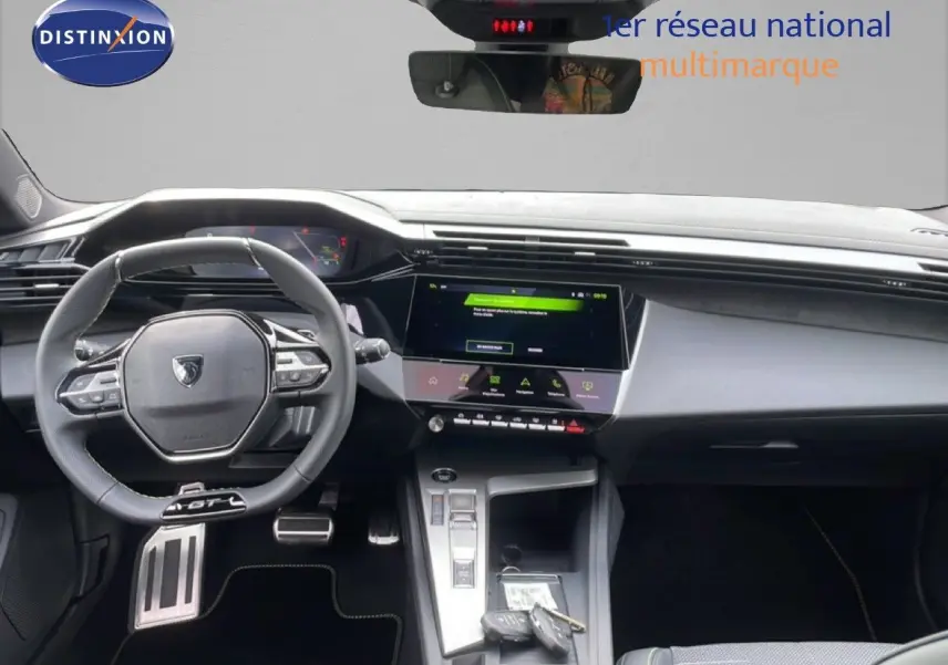 Vue intérieure du tableau de bord et volant cuir noir de la Peugeot 308 1.2 Hybrid 145ch GT, avec écran tactile central.