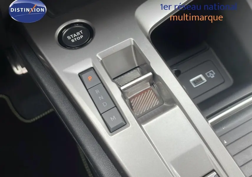 Vue rapprochée de la console centrale grise avec sélecteur de boîte automatique et bouton Start/Stop du Peugeot 308 hybride.