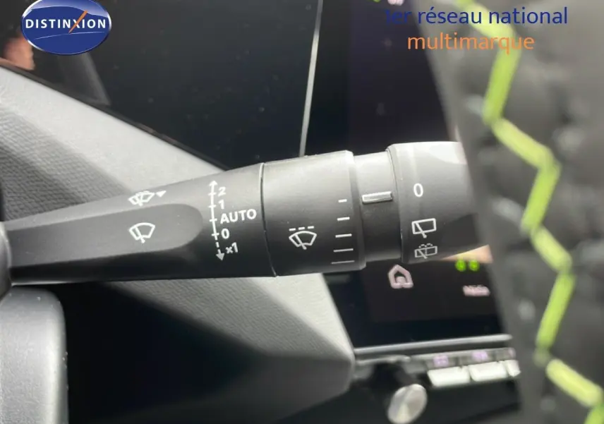 Gros plan sur la commande d'essuie-glace à gauche du volant dans un Peugeot 308 gris Selenium Metal, intérieur noir.