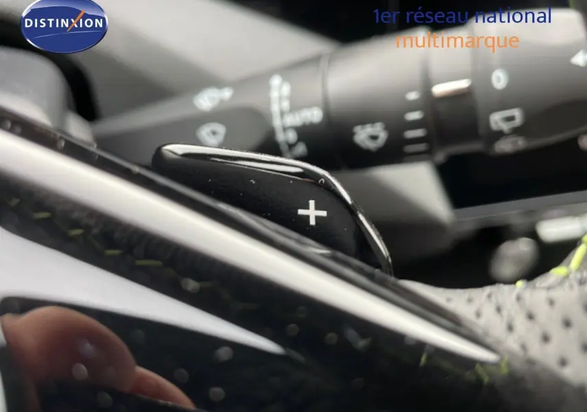 Gros plan sur la palette de changement de vitesse "+" du volant d'une Peugeot 308 gris Selenium Metal, intérieur noir.